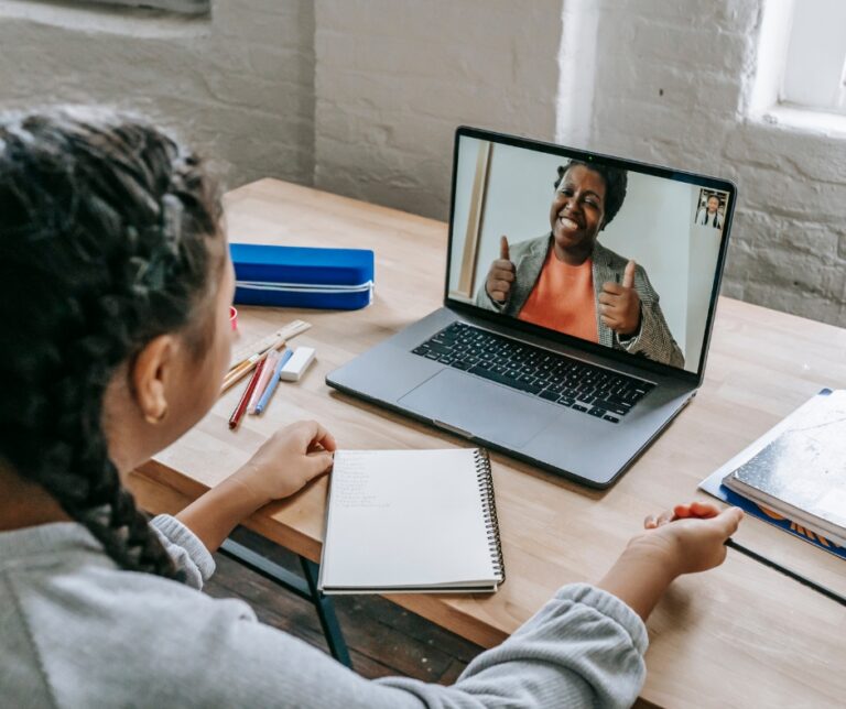 Woman attending an online therapy session with a therapist on a laptop