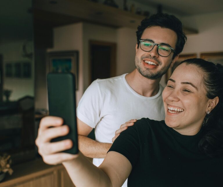 Couple attending virtual therapy session together on a phone from home