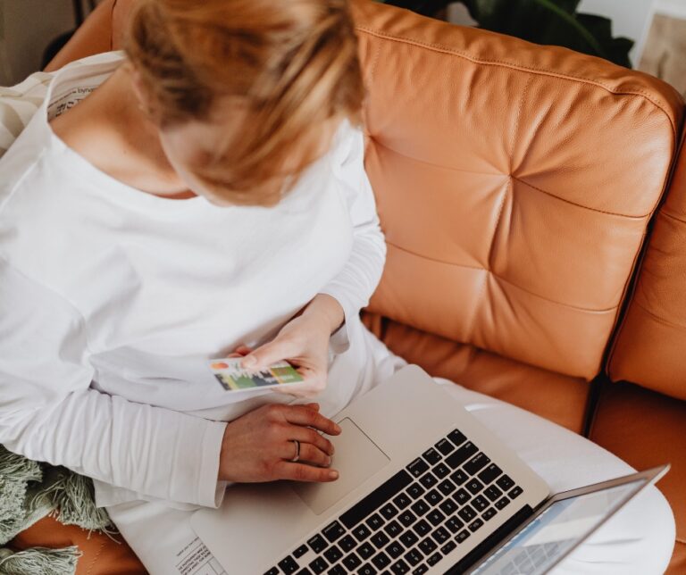 Woman entering credit card information on a laptop while researching therapy costs online