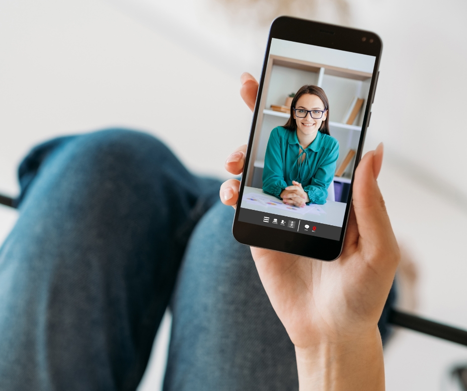 woman participating in a therapy session on her phone from home