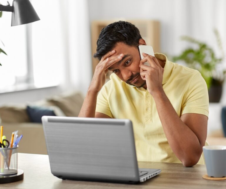 Stressed man participating in an online therapy session from home