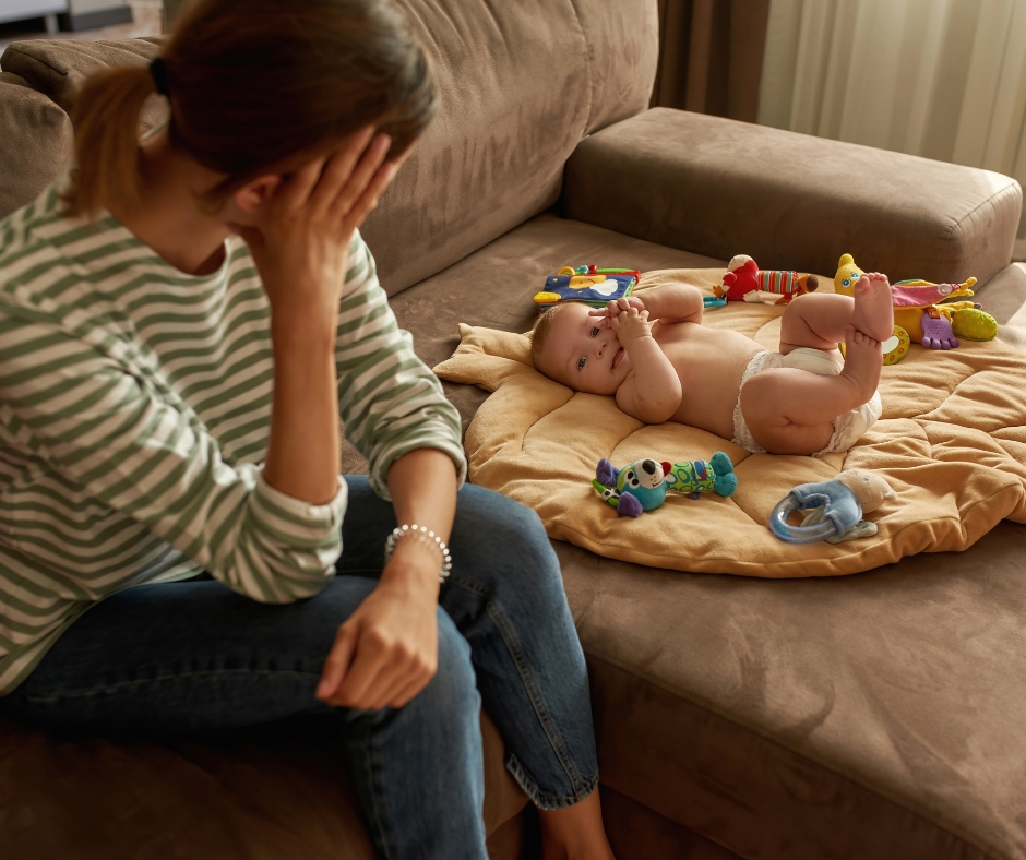 Tired mother watching her child while looking emotionally and physically exhausted