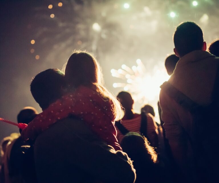People watching a fireworks display together during an evening celebration
