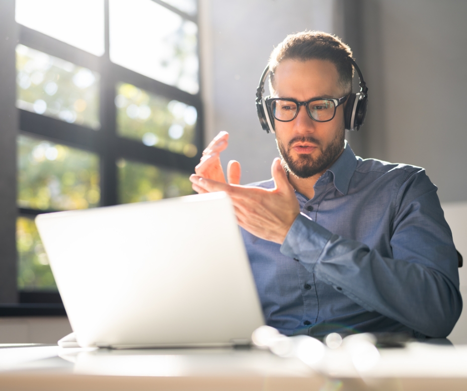 Man participating in an online therapy session from home using a laptop