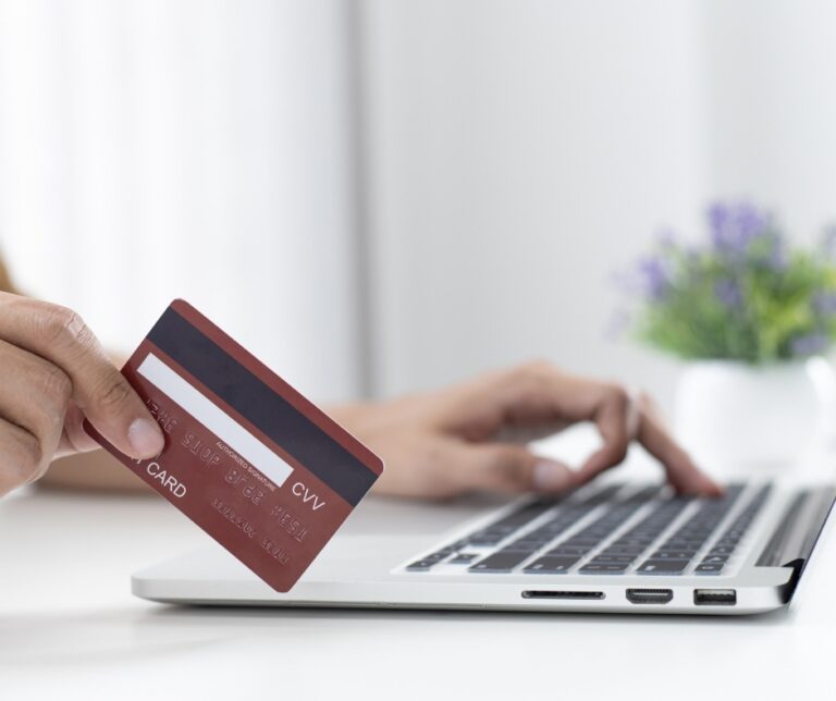 Person making an online payment for a therapy session using a laptop and credit card