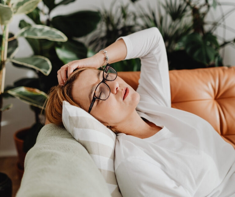 Tired woman resting on a couch, reflecting fatigue and mood changes that can occur with hormonal changes