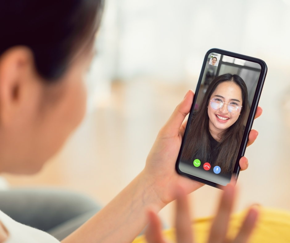 Woman participating in an online therapy session on her phone from home
