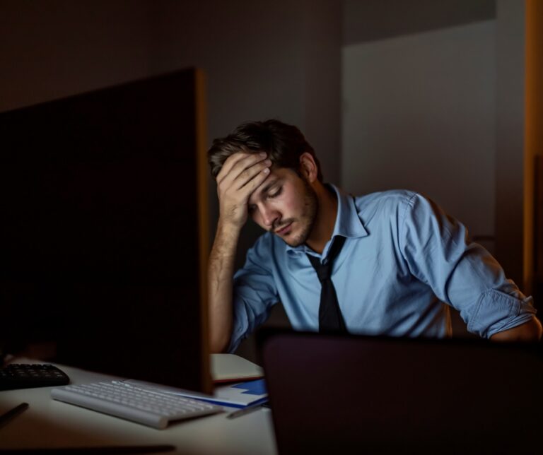 Stressed man experiencing work-related anxiety, burnout, and mental exhaustion